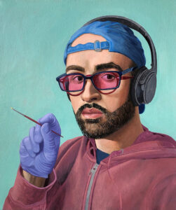 A self-portrait by Francisco Moreno. The artist wears a blue baseball cap backwards with a pair of black wireless headphones over it. He wears a navy blue framed glasses with pink lenses over a pair of maroon framed glasses. He has a short beard and stares straight at the viewer. He wears a navy blue shirt underneath a mauve hoodie. One hand is raised revealing a blue latex glove holding a small, thin maroon paintbrush. The artist is set against a light teal background.