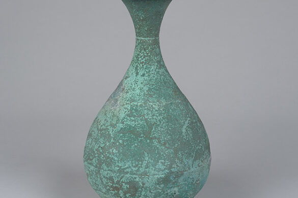 A bronze pear-shaped bottle with a light blue patina.