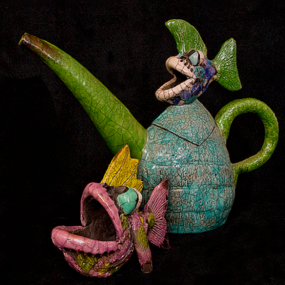 A whimsical clay teapot and cup by Ross de la Garza featuring tropical fish.